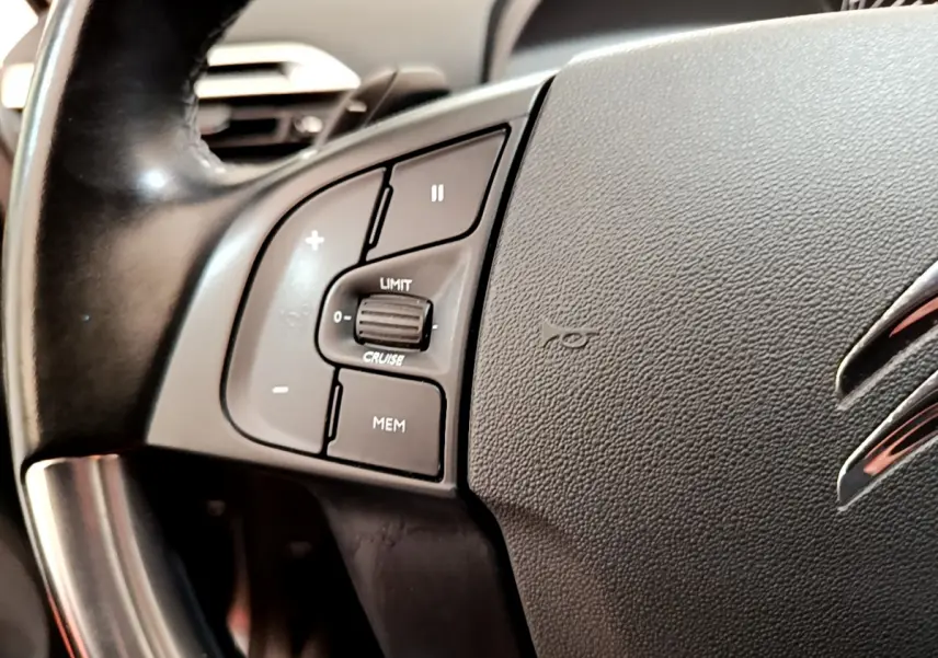 Gros plan sur le volant cuir noir du Citroën Grand C4 Spacetourer avec commandes de régulateur de vitesse.