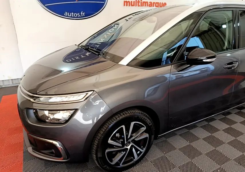 Vue 3/4 avant droit d'un Citroën Grand C4 Spacetourer gris foncé avec jantes alliage et phares LED distinctifs.