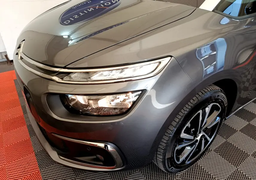Vue 3/4 avant droit d'un Citroën Grand C4 Spacetourer gris foncé avec phares LED et jantes noires brillantes