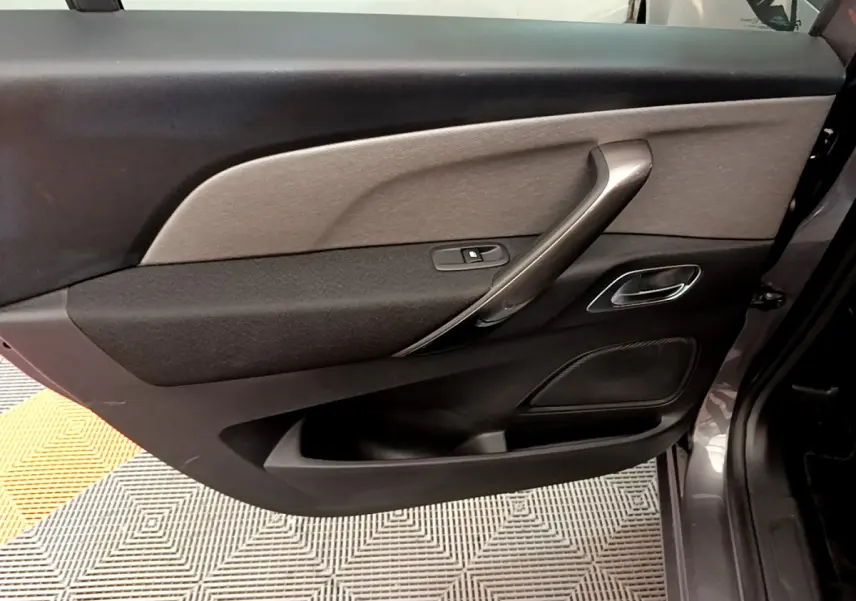 Vue intérieure de la porte côté droit gris foncé du Citroën Grand C4 Spacetourer avec poignée argentée et commande de vitre.