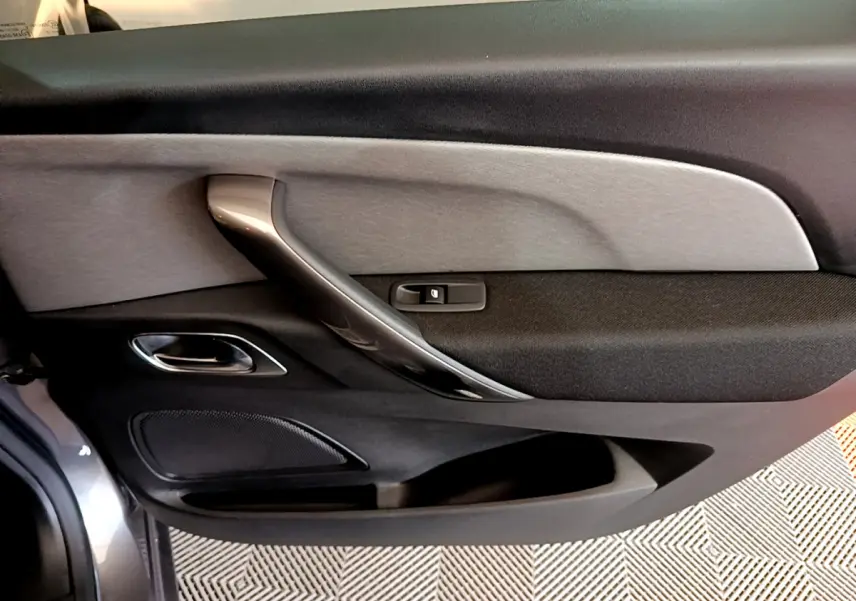 Gros plan sur la porte côté conducteur du Citroën Grand C4 Spacetourer gris foncé, avec poignée intérieure argentée.