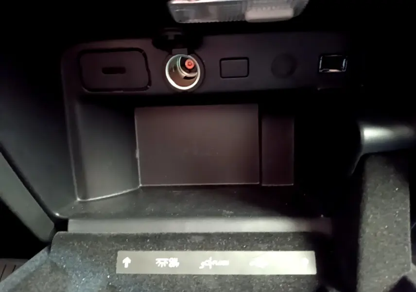 Prise allume-cigare et port USB dans le rangement central noir du Citroën Grand C4 SpaceTourer 2022.