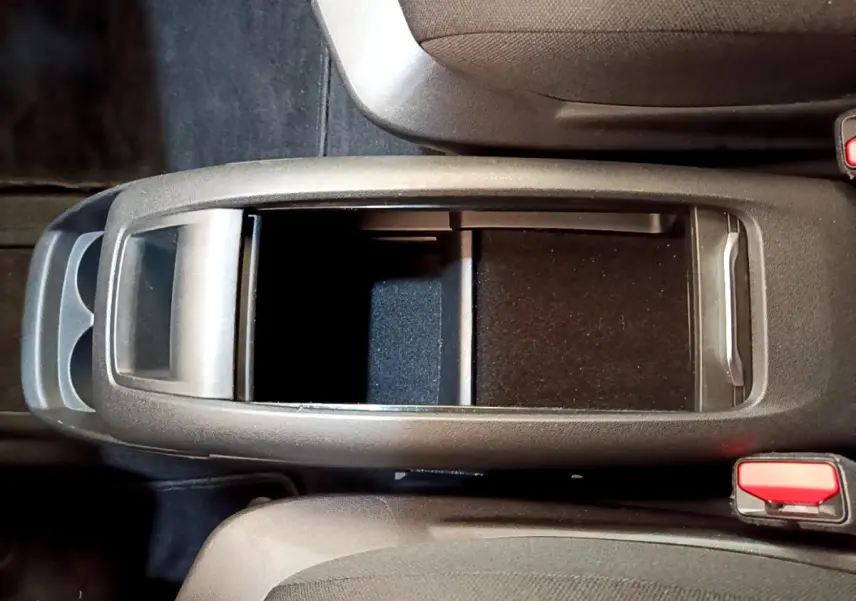 Vue plongeante sur le rangement central noir entre les sièges avant du Citroën Grand C4 SpaceTourer gris foncé 2022.