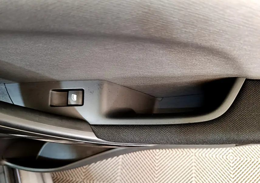 Bouton de déverrouillage porte arrière côté gauche du Citroën Grand C4 SpaceTourer gris foncé, vue rapprochée intérieure.
