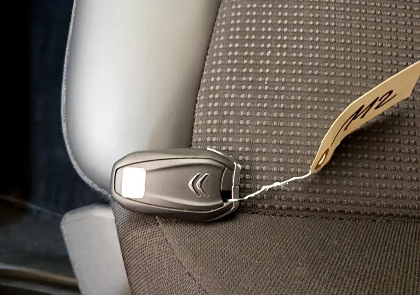 Clé de démarrage noire Citroën posée sur un siège tissu gris foncé à motifs carrés dans un Grand C4 Spacetourer 2022.