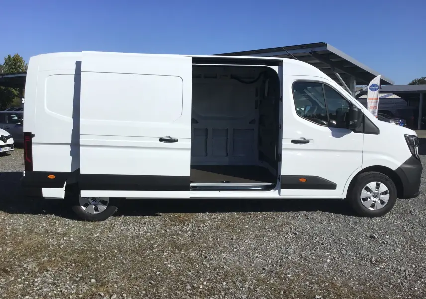 Vue latérale droite d’un Renault Master blanc 2025 avec porte coulissante ouverte montrant l’espace de chargement vide.