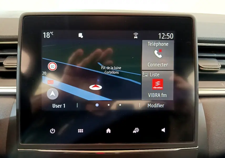 Écran tactile central du tableau de bord du Renault Captur Business noir, affichant navigation et options téléphone à 12h50.