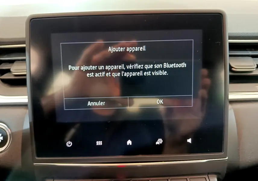 Écran tactile central affichant le message Bluetooth dans l’habitacle du Renault Captur noir, vue frontale rapprochée.