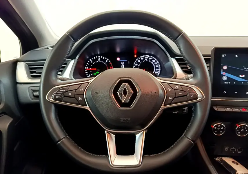Vue rapprochée du volant noir de Renault Captur 2020 avec tableau de bord et écran tactile central visibles.