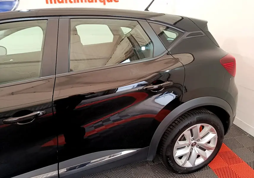 Vue côté droit arrière d'un Renault Captur noir 2020 avec jantes alliage et poignées de porte ton caisse.