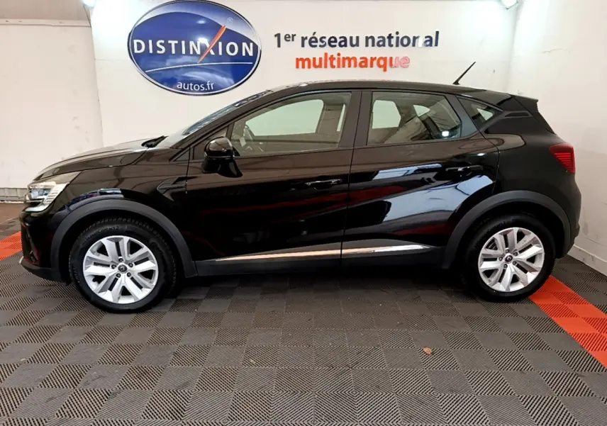 Profil côté gauche du Renault Captur Business Blue dCi 95 noir, vue intérieure d'un showroom avec logo Distinxion en arrière-plan.