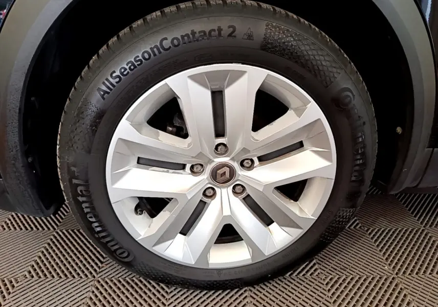 Gros plan sur la roue avant gauche du Renault Captur noir, mettant en valeur la jante alliage et le pneu Continental AllSeasonContact 2.