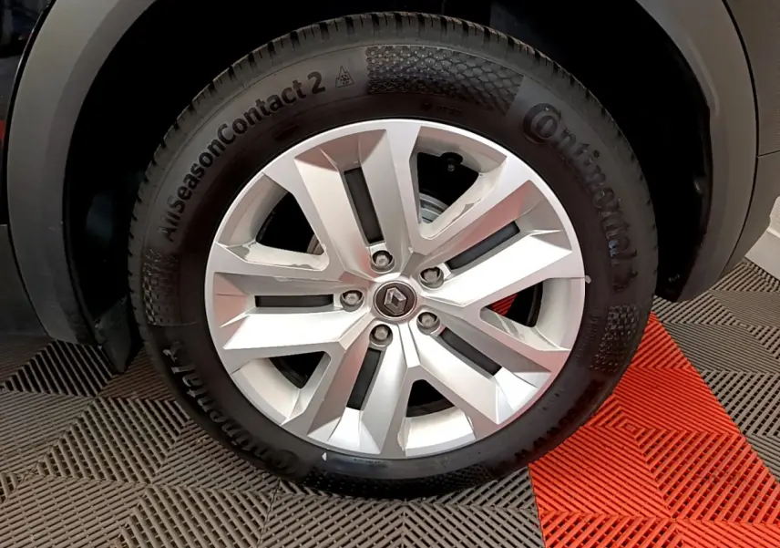 Gros plan sur la roue avant droite du Renault Captur noir, mettant en valeur la jante argentée et le pneu Continental.