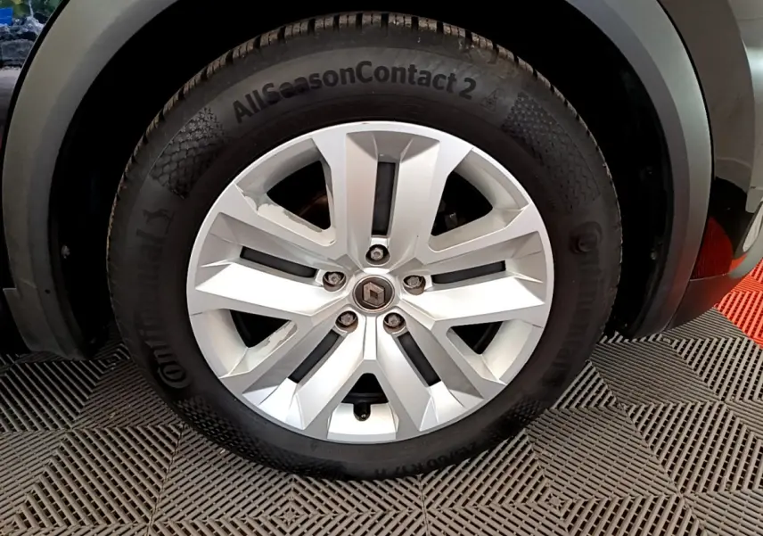 Gros plan sur la roue avant droite avec jante argentée et pneu Continental AllSeasonContact 2 du Renault Captur noir 2020.