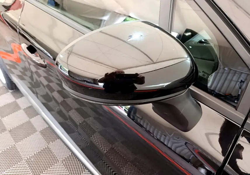 Rétroviseur côté gauche noir brillant d’un Renault Captur Business 2020, vue rapprochée sur la portière et la vitre.