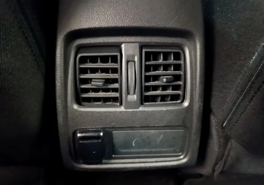 Gros plan sur la sortie d'air arrière noire du Renault Captur Business Blue dCi 95, intérieur sombre.