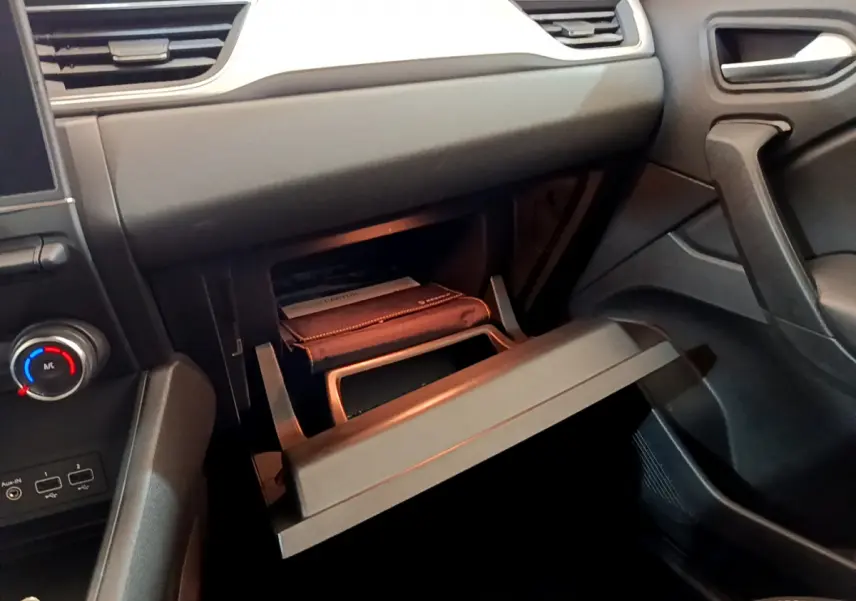 Vue intérieure côté passager du tableau de bord noir du Renault Captur 2020 avec boîte à gants ouverte.