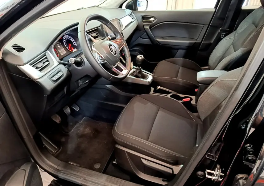 Vue intérieure côté conducteur du Renault Captur noir 2020, montrant volant multifonctions et boîte manuelle.