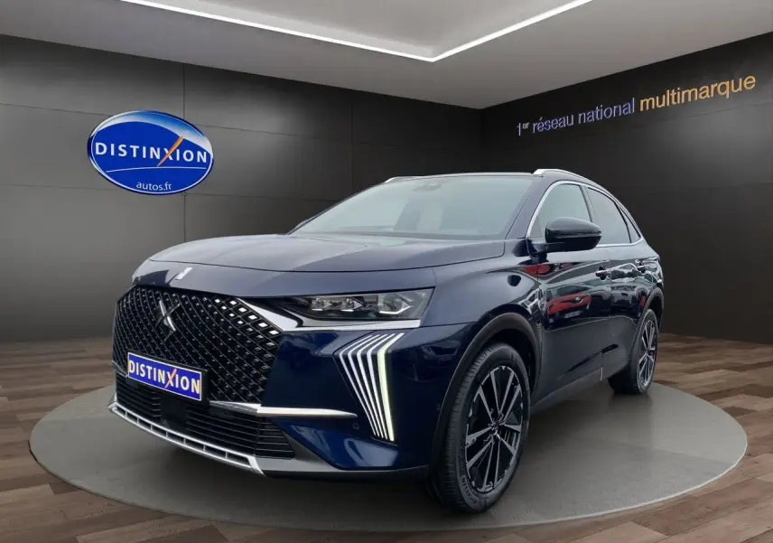 Vue 3/4 avant droit du DS7 2024 bleu éclipse avec calandre distinctive et feux LED en forme de griffes.