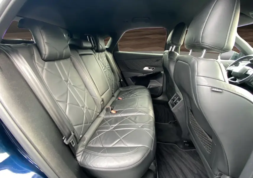 Vue intérieure arrière côté droit du DS7 2024 bleu Eclipse, avec sellerie cuir noir électrique et finitions élégantes.
