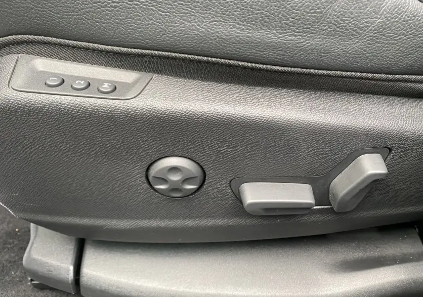 Détail des commandes de réglage électrique du siège en cuir noir du DS7 2024, côté gauche.