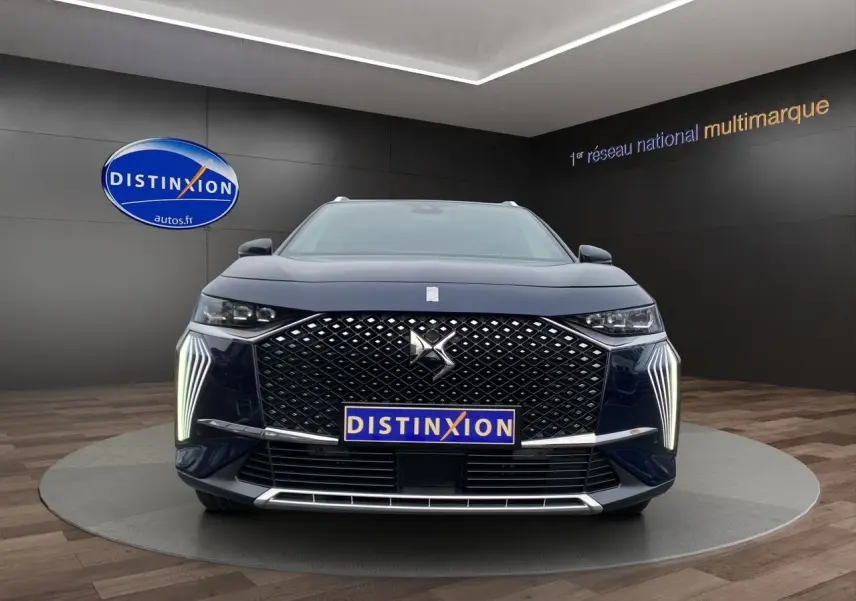 Vue frontale d'un DS7 Bleu Éclipse 2024 avec calandre distinctive et feux LED verticaux allumés.