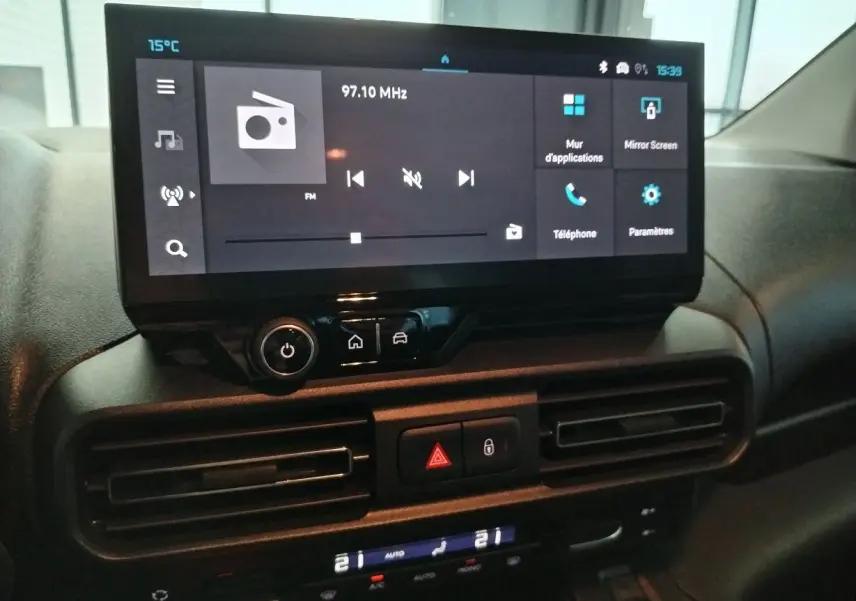 Vue rapprochée de l’écran tactile central du tableau de bord du Citroën Berlingo 2025 avec commandes numériques et climatisation.