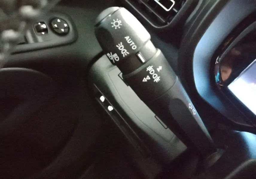 Gros plan sur la commande des feux et clignotants noire dans l’habitacle du Citroën Berlingo blanc 2025.