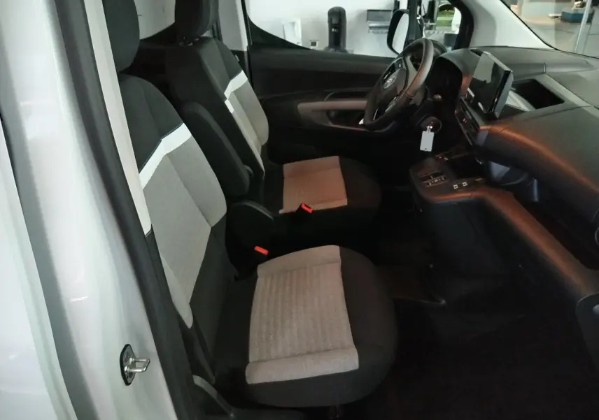 Vue intérieure côté gauche du Citroën Berlingo blanc 2025, montrant les sièges avant bi-ton et le tableau de bord moderne.