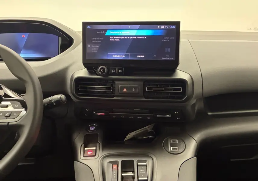 Vue intérieure du tableau de bord du Peugeot Rifter avec écran tactile central et volant multifonction noir.