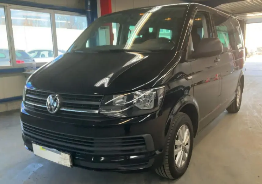 Volkswagen Multivan T6 noir vu en 3/4 avant droit dans un garage avec calandre et phares nets.