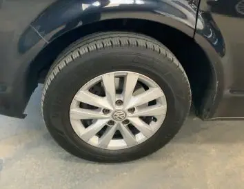 Gros plan sur la roue avant droite d’un Volkswagen Multivan noir T6 PH.1 avec jante alliage et logo VW visible.