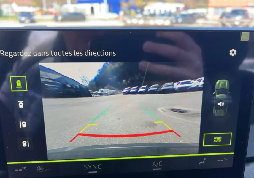 Écran de caméra multiview montrant une vue arrière dégagée du parking du Dacia Bigster Hybrid 155 Expression Plus vert cèdre.