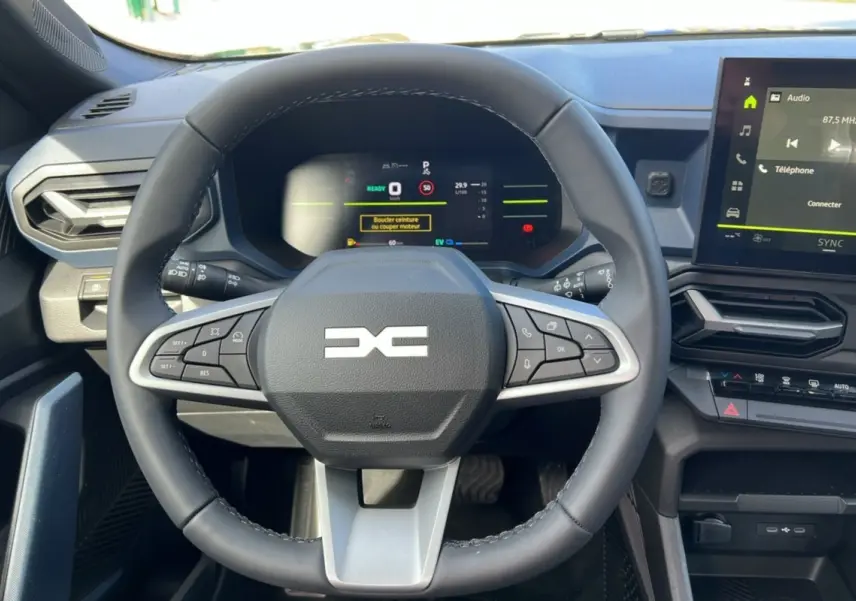 Vue rapprochée du volant cuir noir et du tableau de bord numérique du Dacia Bigster Hybrid 155 Expression Plus.