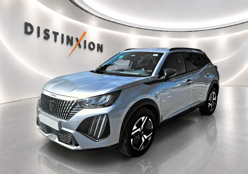 Peugeot 2008 gris Artense vue 3/4 avant droit, avec calandre distinctive et jantes alu noires et argentées.
