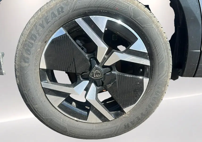 Gros plan sur la jante alu bicolore noire et argentée du côté gauche d’un Peugeot 2008 gris Artense.