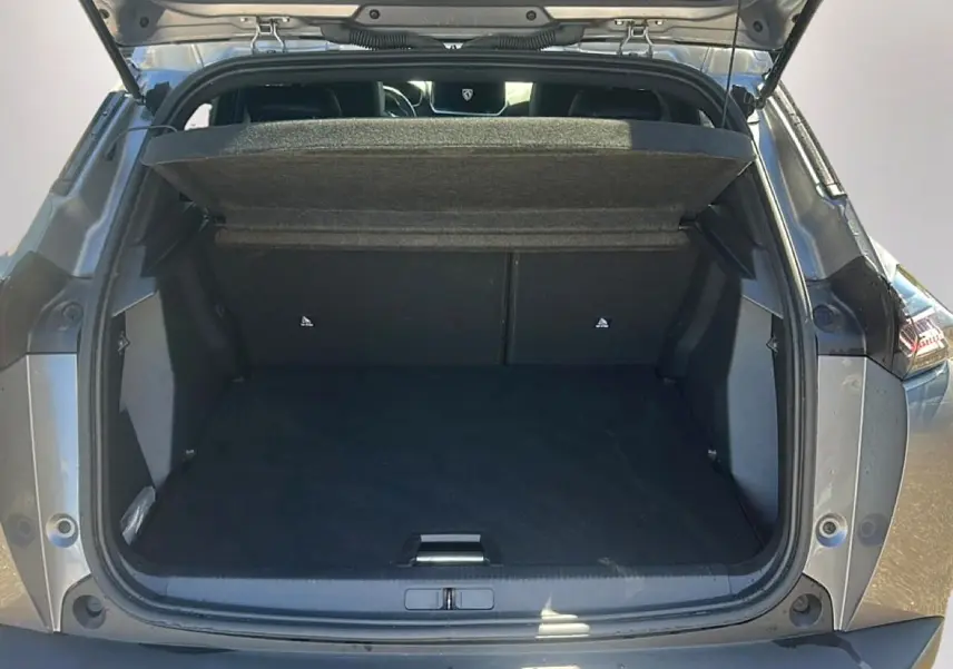 Coffre ouvert vu de l'arrière d'un Peugeot 2008 gris artense avec cache-bagages relevé.