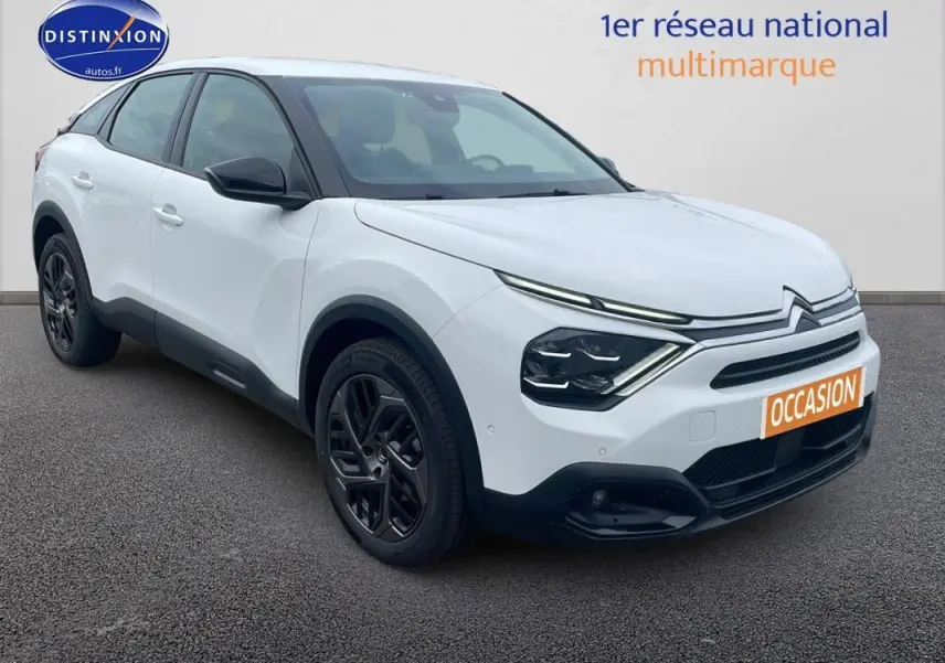 Vue 3/4 avant d'une Citroën C4 blanche avec jantes alliage noires et calandre distinctive moderne.