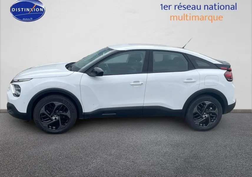 Profil côté gauche d'une Citroën C4 blanche 2022 avec jantes alliage noires et lignes modernes distinctives.