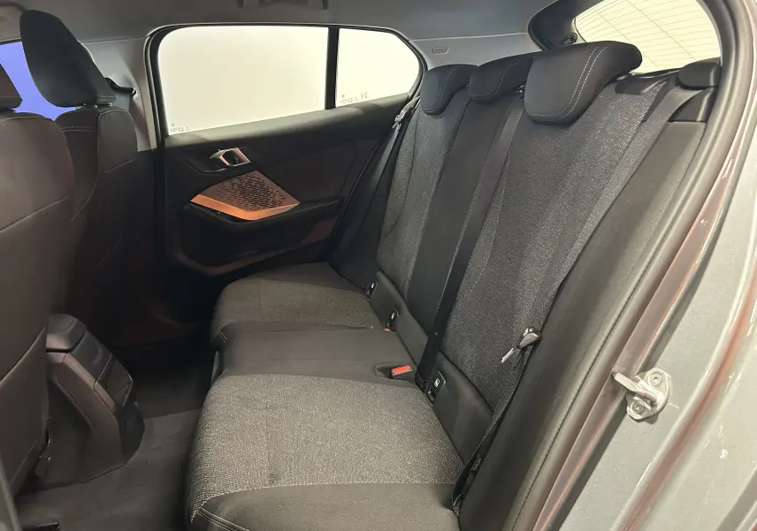 Vue intérieure côté droit des sièges arrière en tissu gris de la BMW Série 1 120DA M Sport 2024 gris Skyscrap.