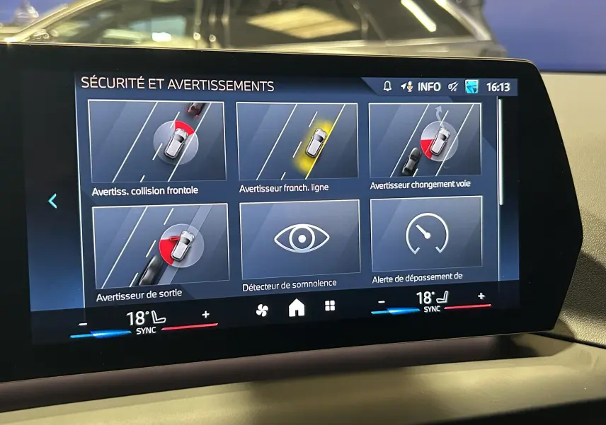 Écran central de la BMW Série 1 120DA M Sport 2024 montrant les alertes de sécurité et avertissements du véhicule.