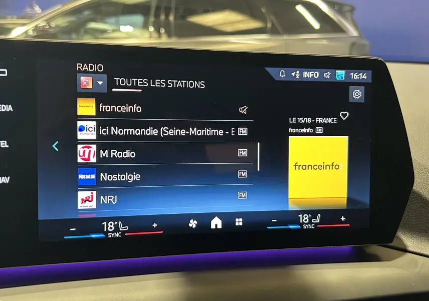 Écran tactile intérieur de la BMW Série 1 120DA M Sport 2024 affichant les stations radio avec ambiance lumineuse violette.