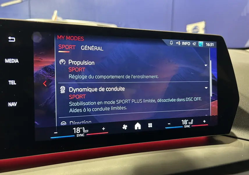 Écran tactile central de la BMW Série 1 120DA M Sport 2024 affichant le mode de conduite Sport dans un intérieur moderne.