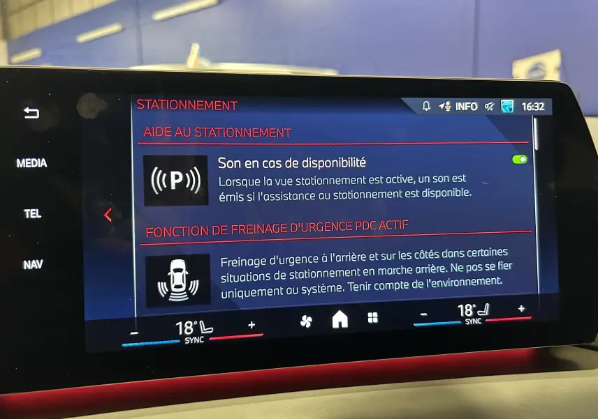 Écran central de la BMW Série 1 120DA 2024 affichant les options d'aide au stationnement et freinage d'urgence.