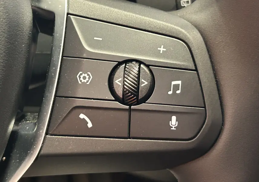 Gros plan sur les commandes audio et téléphone au volant d'une BMW Série 1 120DA gris Skyscrap de 2024.