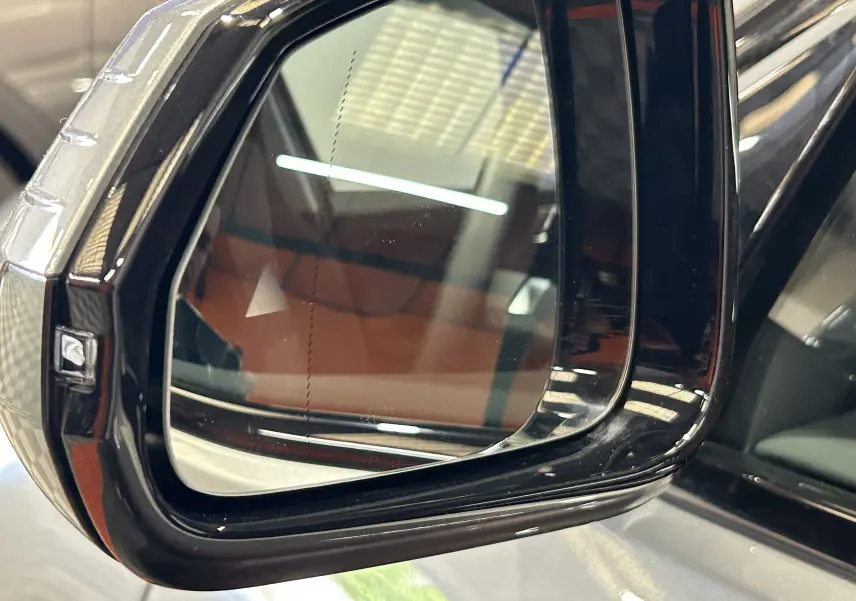 Rétroviseur extérieur droit noir brillant de la BMW Série 1 120DA gris Skyscrap, reflet intérieur et lumière ambiante.