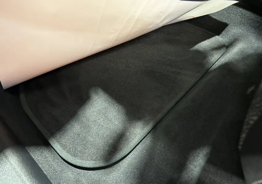 Tapis de sol noir dans l'habitacle d'une BMW Série 1 120DA M Sport Design 2024.