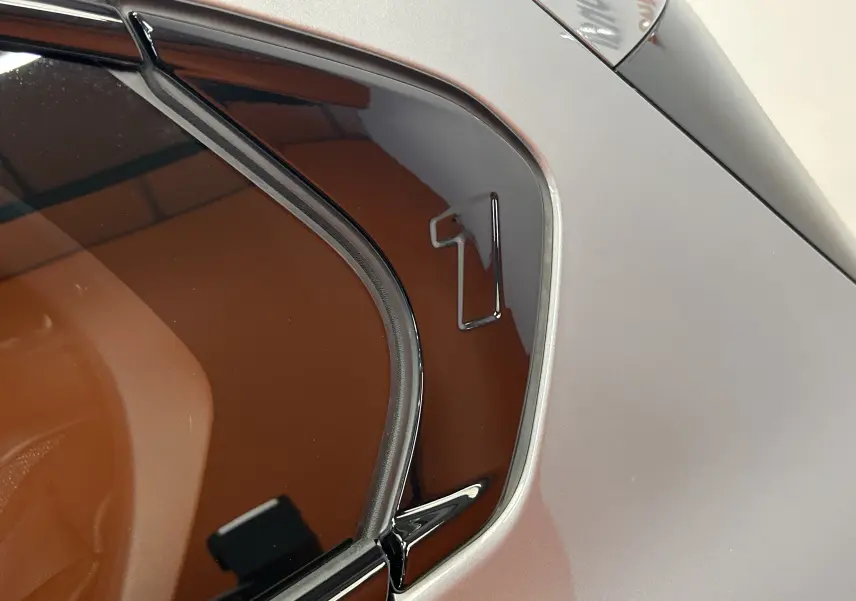 Détail de la vitre arrière côté droit d'une BMW Série 1 gris Skyscrap avec logo "1" noir brillant.