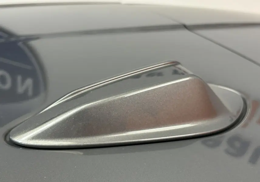 Gros plan sur l'antenne requin grise métallisée posée sur la carrosserie gris Skyscrap d'une BMW Série 1 2024.
