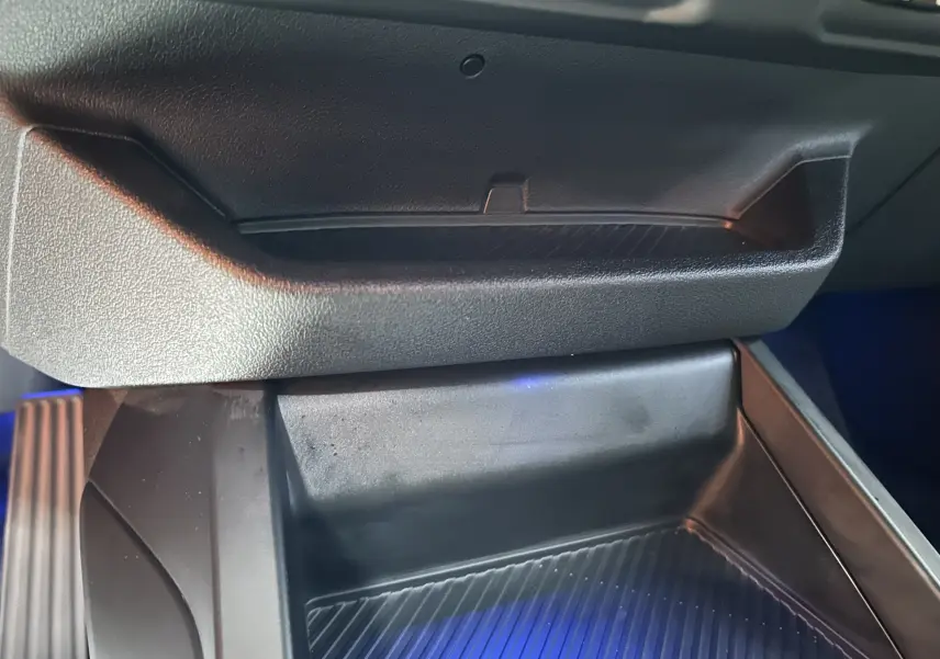 Gros plan sur le rangement central noir de l’habitacle de la BMW Série 1 120DA M Sport 2024.